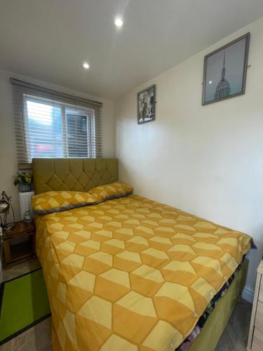 a bedroom with a bed with a yellow bedspread at Mitcham Let 11 in Mitcham