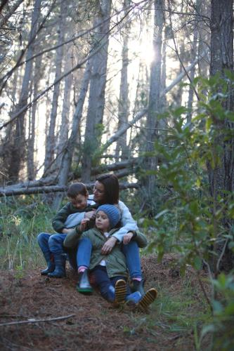 a woman and two children sitting in the woods at A Hilltop Country Retreat in Swellendam
