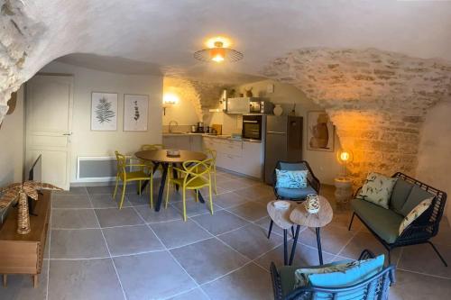PujautにあるPujaut , Gîte cœur de village « sous le clocher»のキッチンとテーブルと椅子のあるリビングルーム