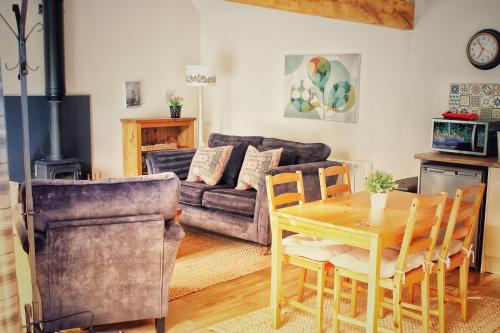 a living room with a table and a couch at Cosy One Bed Barn Conversion Donington Park East Midlands Airport in Derby