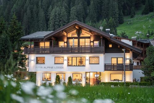 una casa grande con muchas ventanas en Arya Alpine Lodge en Selva di Val Gardena