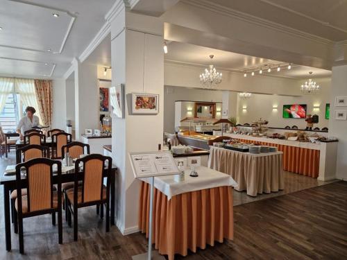 um restaurante com mesas e cadeiras num quarto em artHOTEL Bremen em Bremen