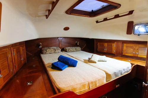 a bed in the back of a boat with blue pillows at Alejandro Magno in Ponta Delgada