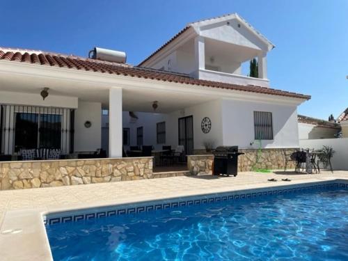 una casa con piscina frente a una casa en Casa Pap, en Arboleas