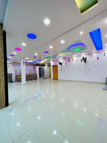 a large empty room with a white floor and blue lights at Smart Stays - MMMUT College - GKP Airport in Gorakhpur
