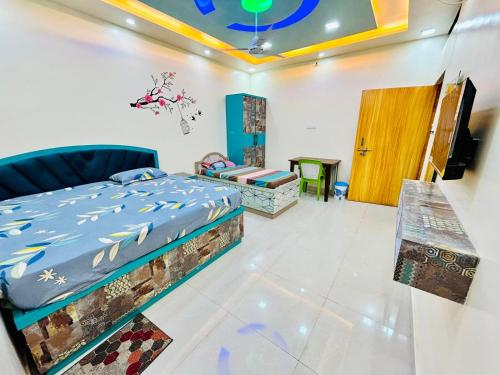 a bedroom with a bed and a table and a door at Smart Stays - MMMUT College - GKP Airport in Gorakhpur