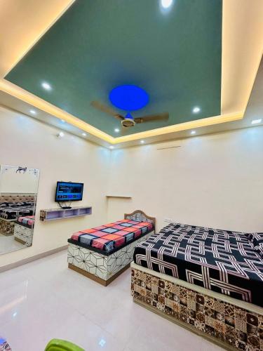 a bedroom with two beds and a blue ceiling at Smart Stays - MMMUT College - GKP Airport in Gorakhpur