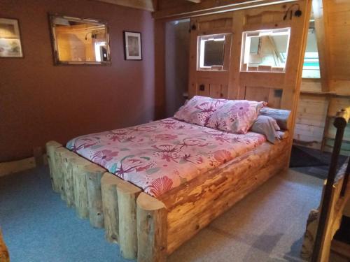 a bed with a wooden frame in a room at L' Auberge du château in Génos