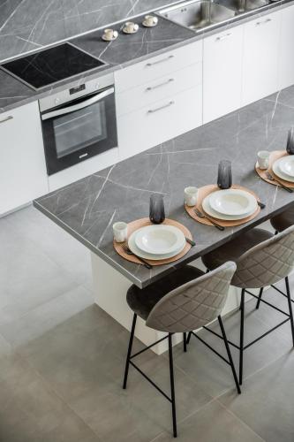 a kitchen with a table with plates and chairs at Vathy Villas in Preveza