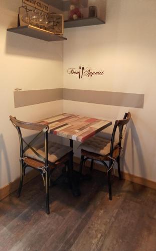 a table and chairs in a room with a sign on the wall at L' Auberge du château in Génos