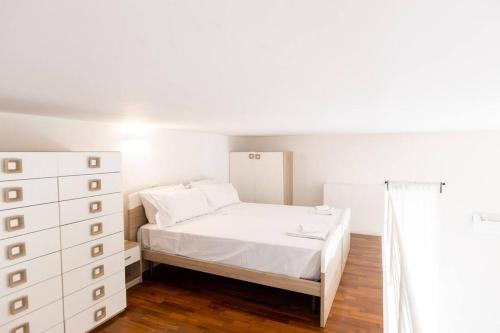 ein Schlafzimmer mit einem weißen Bett und einer Kommode in der Unterkunft Loft2 via morosini centro Varese - Ixihome in Varese