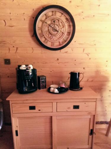 a clock on the wall above a wooden cabinet at L' Auberge du château in Génos