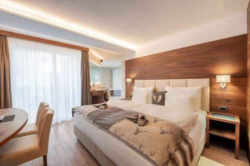 a bedroom with a large bed with two dogs on it at Arya Alpine Lodge in Selva di Val Gardena