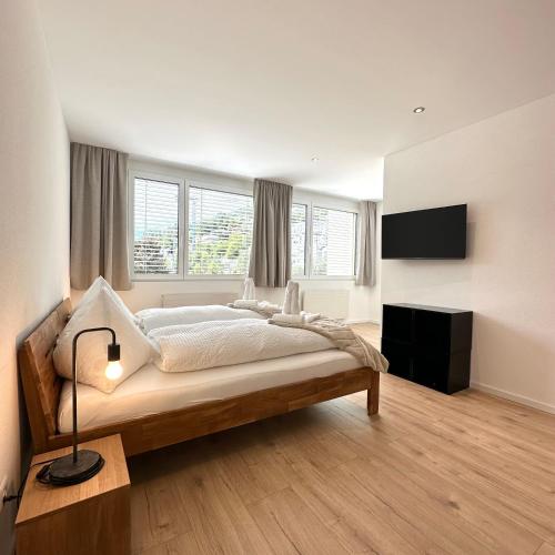 a bedroom with a large bed and two windows at Hotel Rätia in Ilanz