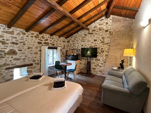 uma sala de estar com uma cama, um sofá e uma televisão em Domaine de Brise Bois em Rouzède