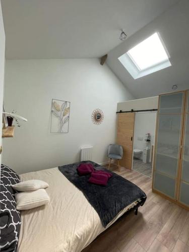 a bedroom with a large bed and a skylight at Maison Les Iris - 3 chambres et 3 salles de bain - 3 à 6 personnes - Futuroscope in Avanton