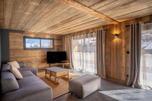 uma sala de estar com um sofá e uma televisão em Appartement Les Myrtilles - pied des pistes - 10 personnes em Les Deux Alpes