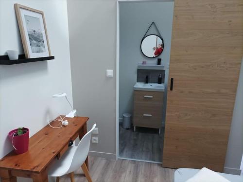 a dining room with a wooden table and a mirror at Maison Les Iris - 3 chambres et 3 salles de bain - 3 à 6 personnes - Futuroscope in Avanton