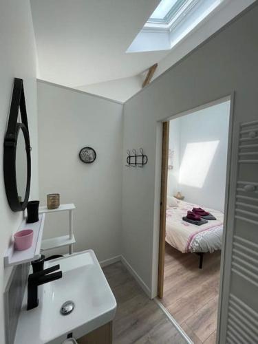 a bathroom with a sink and a mirror and a bed at Maison Les Iris - 3 chambres et 3 salles de bain - 3 à 6 personnes - Futuroscope in Avanton