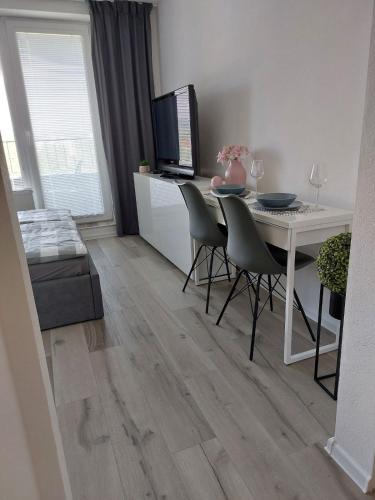 a living room with a table and chairs and a television at Apartment A&B Poprad in Poprad