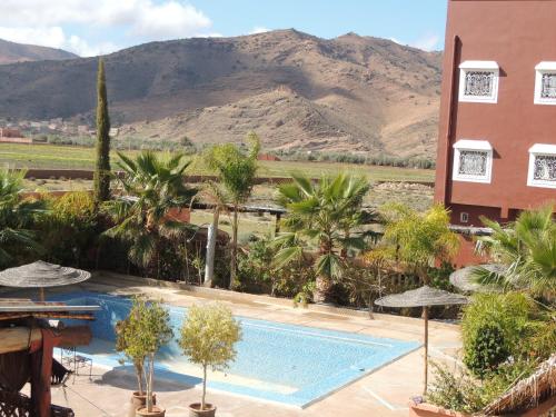 um resort com piscina e montanhas ao fundo em Auberge Kasbah Amoun em Taliouine