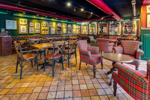 a restaurant with tables and chairs and paintings on the walls at Gordion Hotel - Special Class in Ankara
