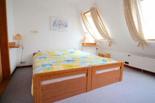 a bedroom with a bed in a room with windows at Tetenshof für Pferdeliebhaber in Westerhever