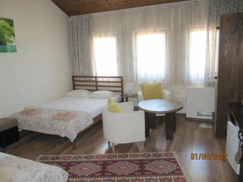 una camera con letto, tavolo e sedie di Guest House Belchin View a Belchin