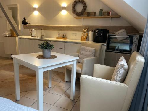 a living room with a table and chairs and a kitchen at Weberhof - Münster 6 in Münster