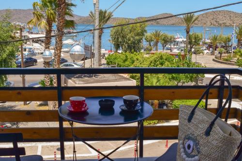 two cups of coffee on a table on a balcony at Boho Sea View Apartment in Elounda