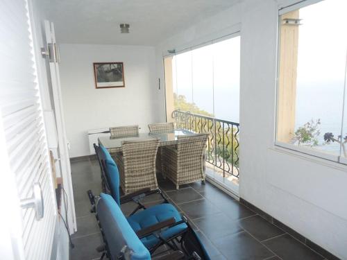 un balcon avec une table, des chaises et une fenêtre dans l'établissement Bel appartement 2 chambres vue mer panoramique, à Cavalaire-sur-Mer