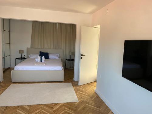 Schlafzimmer mit einem Bett und einem Flachbild-TV in der Unterkunft Zadar Penthouse in Zadar