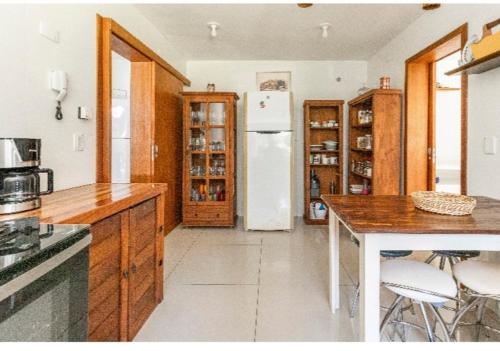 a kitchen with a refrigerator and a table and chairs at Bèlla Chacara Morretes - Pr in Morretes