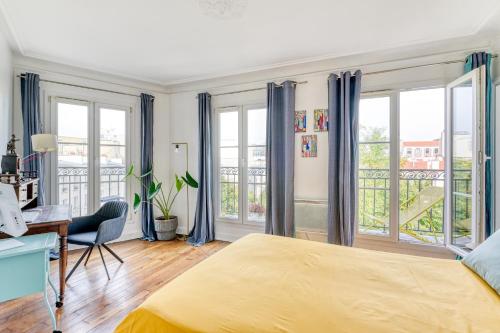 um quarto com uma cama amarela, uma secretária e janelas em Stunning Apartment 2br + balcony + nice view em Paris