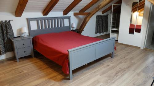 a bedroom with a large bed with a red bedspread at Casa vacanze - alloggio agrituristico Col in Monrupino