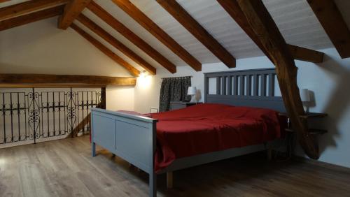 Casa vacanze - alloggio agrituristico Col في Monrupino: غرفة نوم بسرير ولحاف احمر