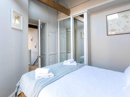 een slaapkamer met een groot wit bed met handdoeken erop bij The Coach House - Unique split level property in Kent