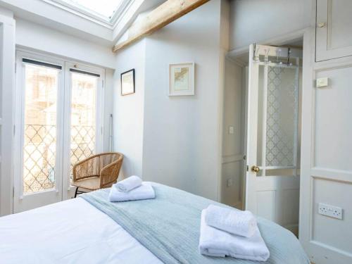 een slaapkamer met een bed met twee handdoeken erop bij The Coach House - Unique split level property in Kent