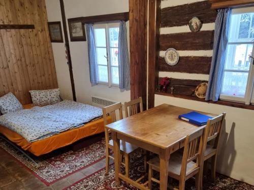 a room with a table and a bed and a desk at Mlýn u skály in Deštné v Orlických horách