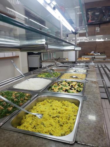 a kitchen with a bunch of trays of food at Pousada Salomão in Teixeira de Freitas