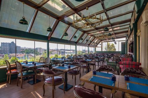 a dining room with tables and chairs and windows at Gordion Hotel - Special Class in Ankara