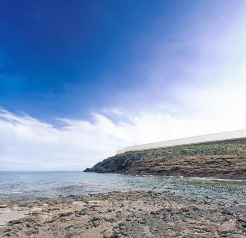 una playa rocosa con vistas al océano en Villa Mi Olvido V.V., en Sardina