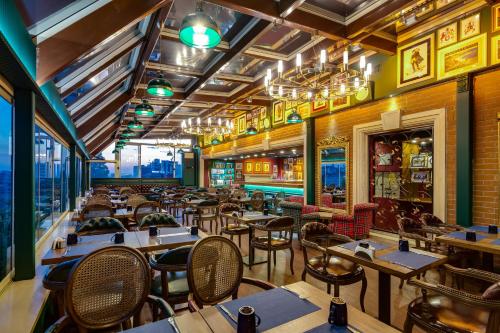 a restaurant with tables and chairs in a room at Gordion Hotel - Special Class in Ankara