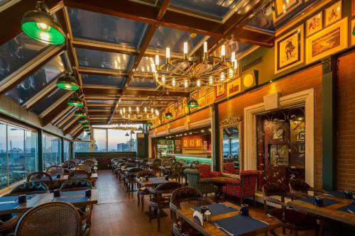 a dining room with tables and chairs and windows at Gordion Hotel - Special Class in Ankara