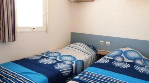 - une chambre avec 2 lits à rayures bleues et blanches dans l'établissement MOBILOCAMP, au Muy