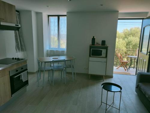 a kitchen and living room with a table and chairs at Maison Chez Laurent in Figari