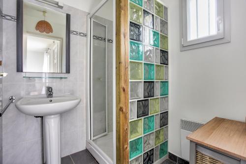La salle de bains est pourvue d'un lavabo et d'un mur en verre. dans l'établissement La Charline - Maison avec jardin près de la plage, à Fréhel