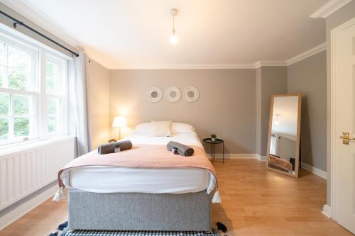 1 dormitorio con cama grande y ventana grande en Bright and modern 4-bed townhouse with garden near town centre, en Kent