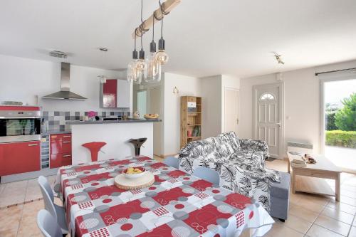 une cuisine et un salon avec une table et des chaises dans l'établissement La Charline - Maison avec jardin près de la plage, à Fréhel