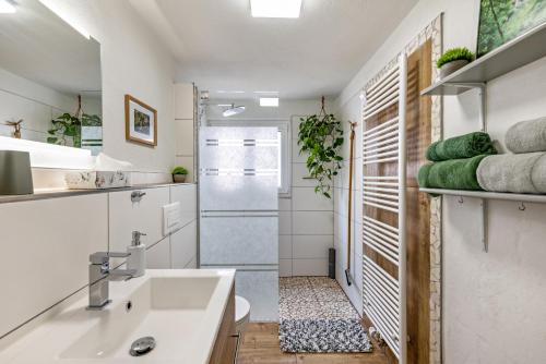 uma casa de banho branca com um lavatório e um chuveiro em La 12 em Bad Urach